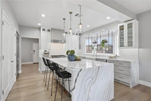 Beautiful, remodeled kitchen with waterfall island in Bianco Lasa marble.